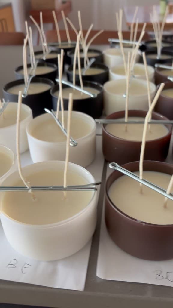 White, black, and amber jars with double wicks held by silver bars
