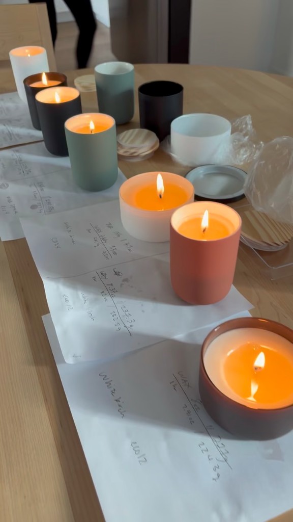 Lit test candles beside handwritten wax-weight and wick notes