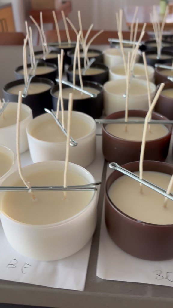 White, black, and amber jars with double wicks held by silver bars