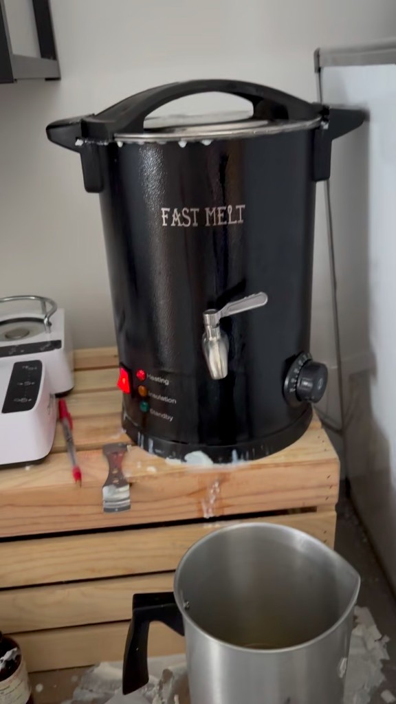 The Fast Melt wax pot on a crate, heating, with a pitcher under the spigot